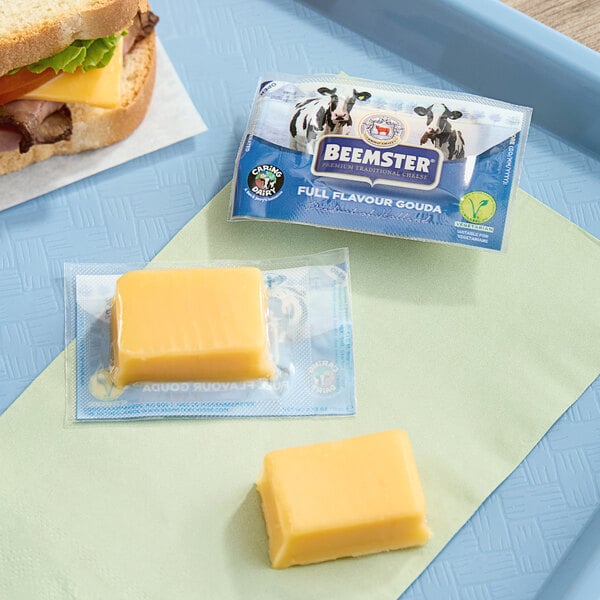 A tray with a sandwich and Beemster Mini Gouda cheese package on it.