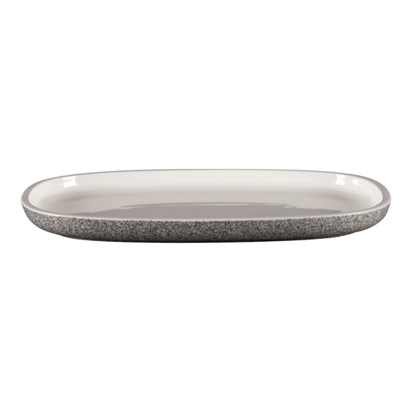 A white oval RAK Porcelain plate with a gray speckled rim.