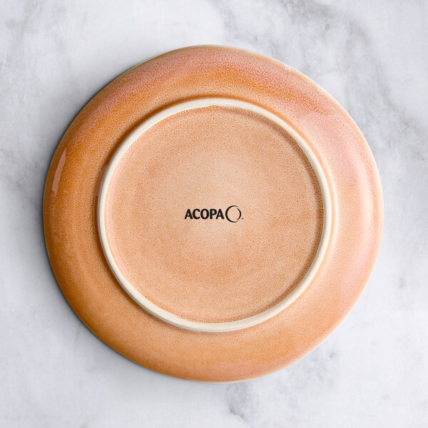 An Acopa Primrose Pink coupe china plate on a marble surface.