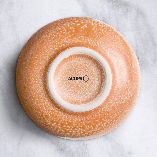 A close-up of a round Primrose pink sauce cup with a white circle in the center.