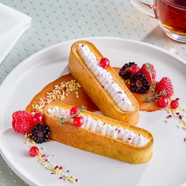 Pavoni Pavoflex oval silicone baking mold with two desserts on a plate.