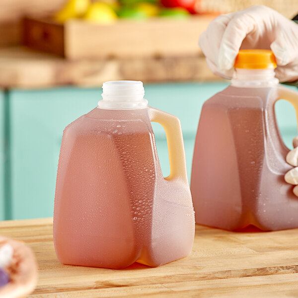 A person holding a translucent HDPE squat jug filled with liquid.