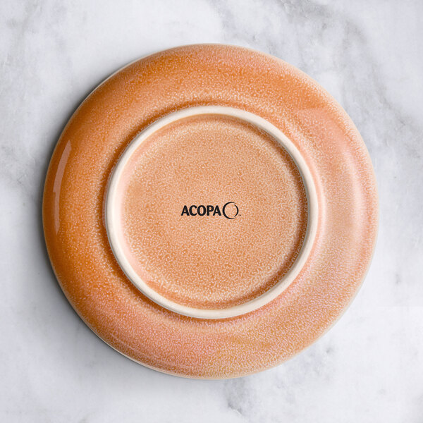 An Acopa Highlands primrose pink coupe china plate with a marble surface.