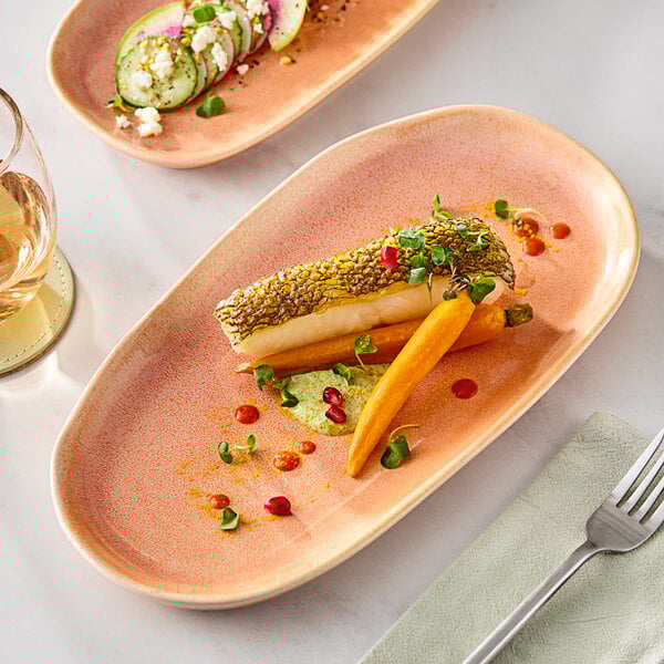 An Acopa Primrose Peach coupe china tray with a plate of food, a fork, and a glass of wine on a table.