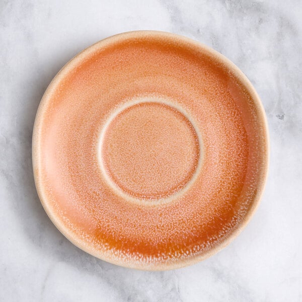 A close-up of an Acopa Primrose Pink saucer with a small hole in the middle.
