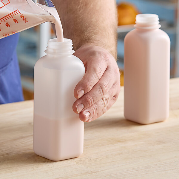 A person pouring milk into a Translucent HDPE square milk bottle.