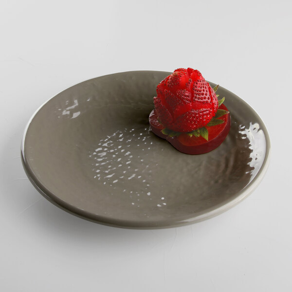 A mushroom-colored Elite Global Solutions round melamine plate with a strawberry on it.