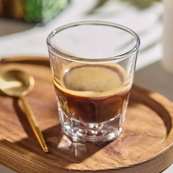 An Acopa Memphis espresso glass of coffee on a table.