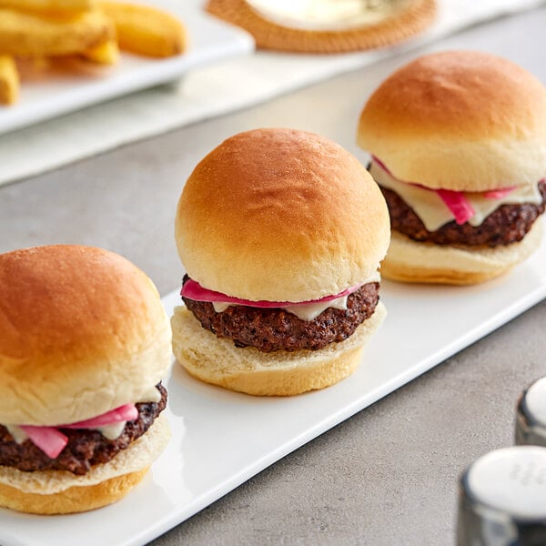 King's Hawaiian Original Hawaiian Sweet Sliced Slider Rolls served with mini burgers on a white plate.