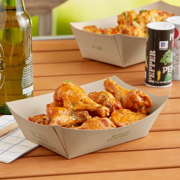 A World Centric compostable paper food tray filled with chicken wings and beer.