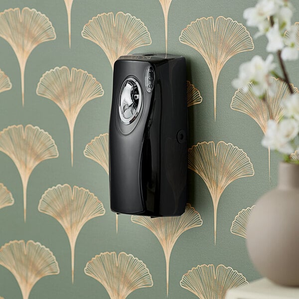 A black F-Matic Aroma air freshener dispenser on a wall.