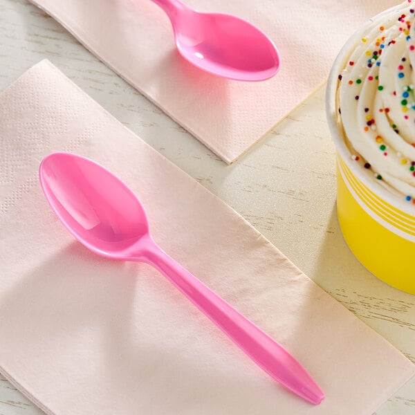 A pink Choice plastic spoon on a napkin.