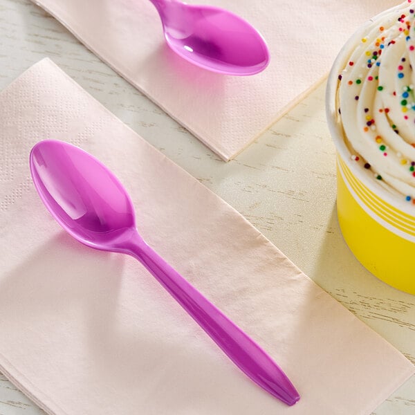 A purple Choice plastic teaspoon on a napkin.