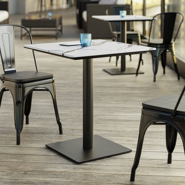 A Lancaster Table & Seating Excalibur table with a smooth finish and square base plate on a patio.