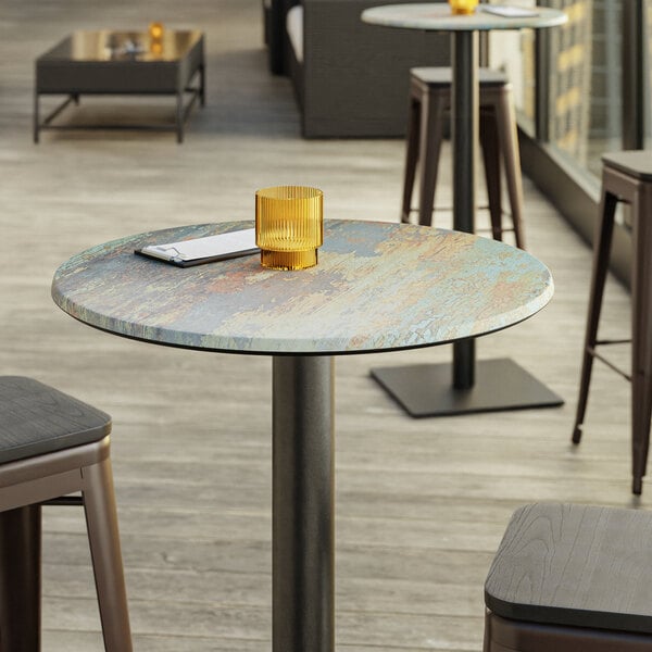 A Lancaster Table & Seating Excalibur round table with a textured yellow metal finish.