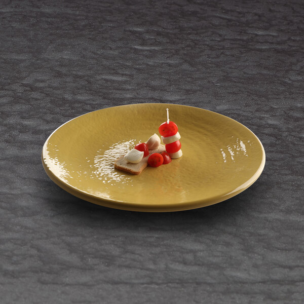 An Elite Global Solutions olive oil-colored melamine plate with food on it.