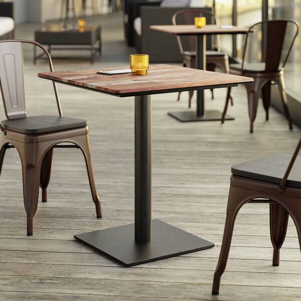 A Lancaster Table with a Textured Yukon Oak Finish and Square Base Plate on a patio with chairs.