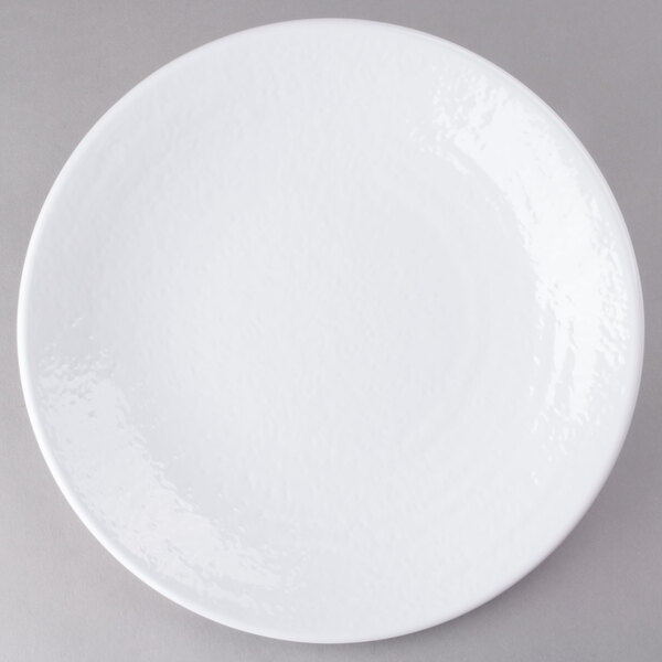 A close-up of an Elite Global Solutions white plate with a white rim on a gray surface.