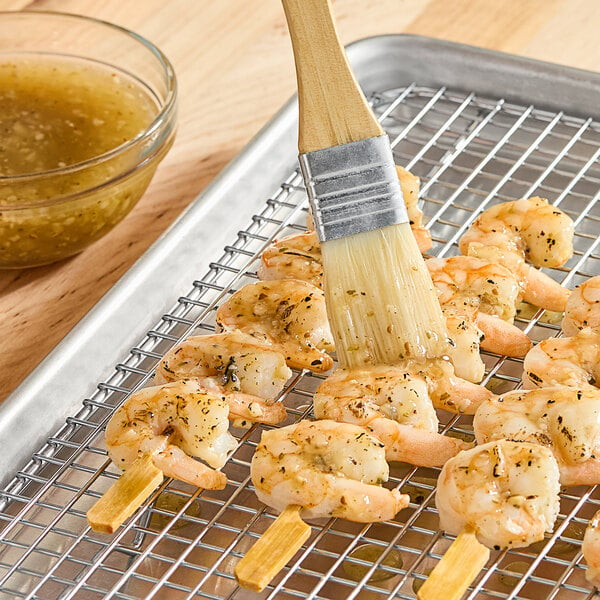 A person using Badia All Purpose Marinade to brush shrimp on a grill.