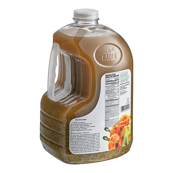 A jug of Badia Mojo Marinade with a brown liquid inside and a lid.