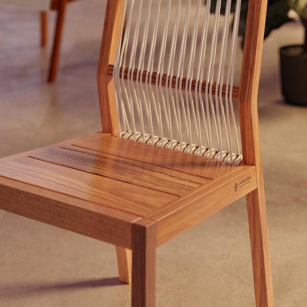 A Lancaster Table & Seating Virelli Brazilian wood outdoor side chair with nautical rope woven seat and back.