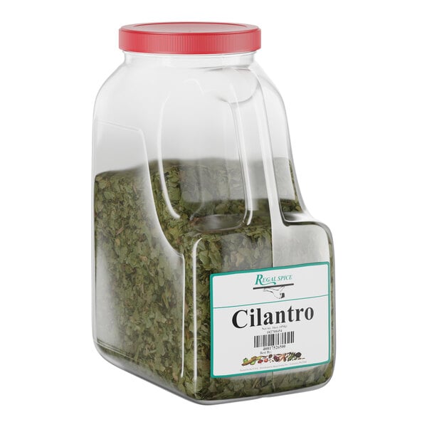 A large plastic container of Regal brand dried cilantro with a red lid.