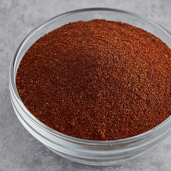 A bowl of Badia chili powder on a gray surface.