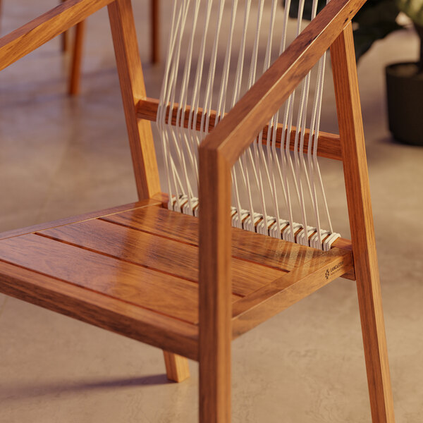 A Lancaster Table & Seating outdoor wooden arm chair with woven nautical rope seat and back.