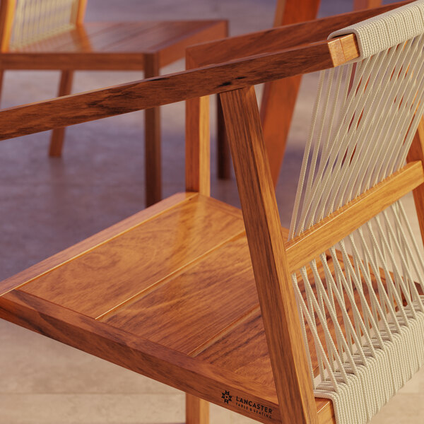 A close-up of a Lancaster Table & Seating wooden arm chair with nautical rope woven seat.