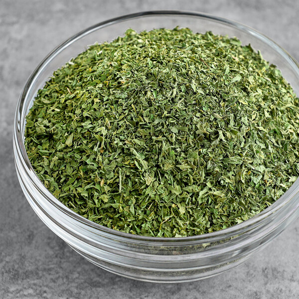A bowl of Badia Parsley Flakes on a table.