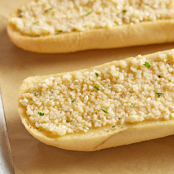 Two breadsticks with Badia Minced Garlic in Olive Oil and cheese on a white surface.