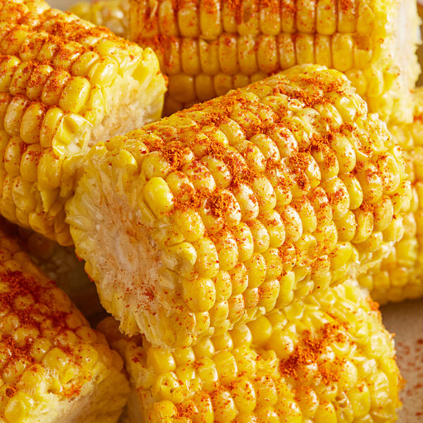 A close up of corn on the cob with red pepper flakes.