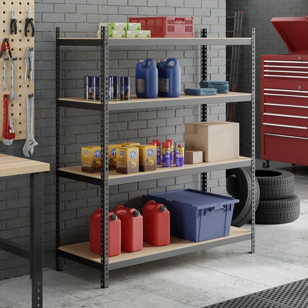 A black heavy-duty four-shelf boltless particle board shelving unit with 72-inch uprights, used for storage in a garage or workshop setting.