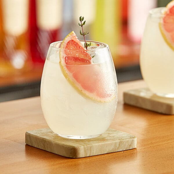 A glass of Paradise grapefruit soda with a slice of grapefruit on the rim.