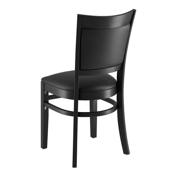 A Lancaster Table & Seating black wood chair with black vinyl cushion.