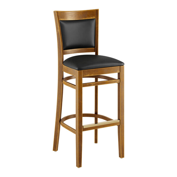 A wooden bar stool with a black vinyl cushion.