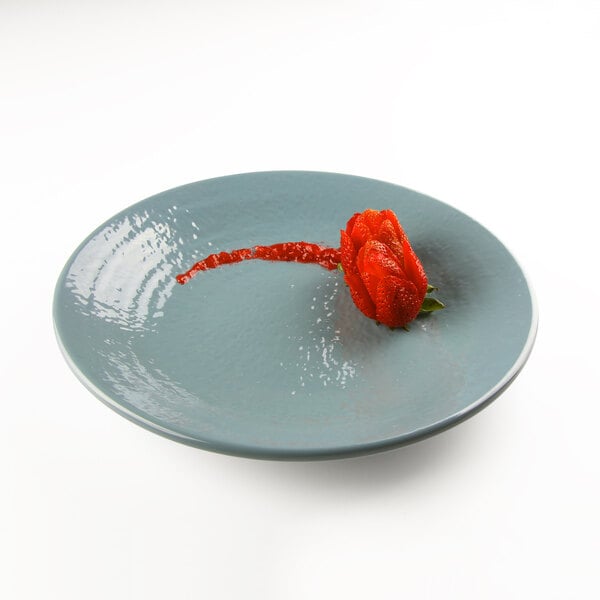 An Elite Global Solutions round melamine plate in white with a red flower design.
