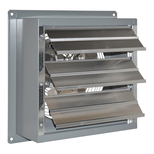 A metal vent with a Canarm wall exhaust fan with four metal blades in the middle.
