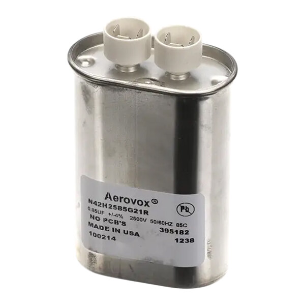 A silver metal capacitor with a white label.