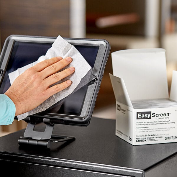 A hand using PDI Healthcare Easy Screen Cleaning Wipes to clean a screen.