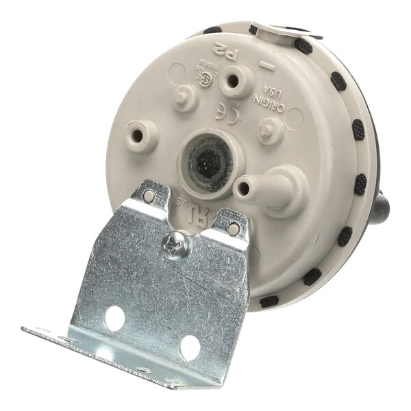 A white Wells vacuum switch with black circles and dots on a metal plate.
