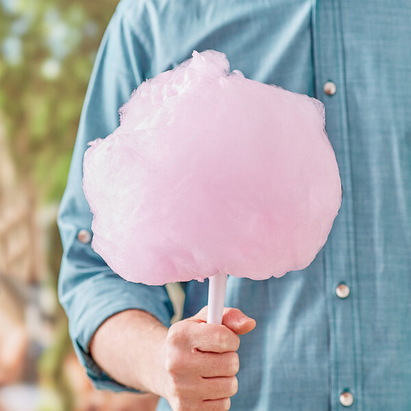 A person holding pink cotton candy spun with Great Western Pink Strawberry Cotton Candy.