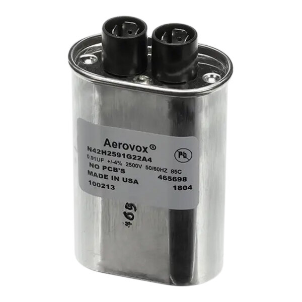 A close up of a silver TurboChef capacitor with black and white labels.