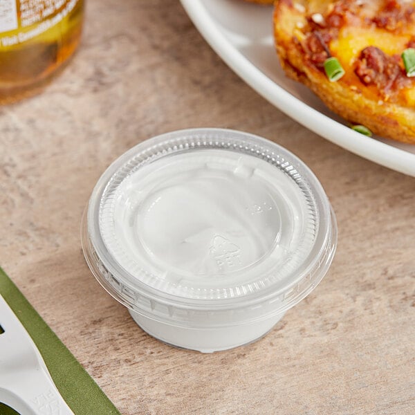 A clear plastic Choice souffle container with white cream inside.