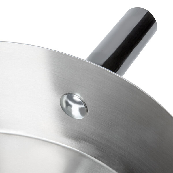 A stainless steel pan with a metal handle and lid.