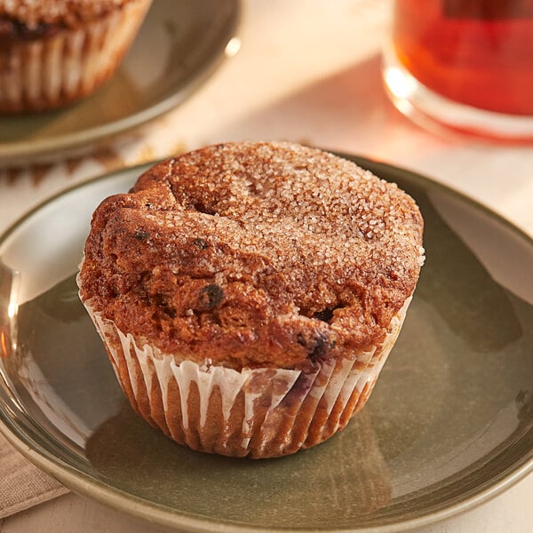 Two OMG...It's Gluten Free blueberry muffins on a plate with a cup of tea.