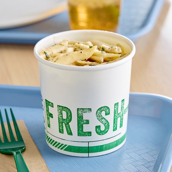 An Innopak poly-coated paper food cup filled with pasta on a tray.