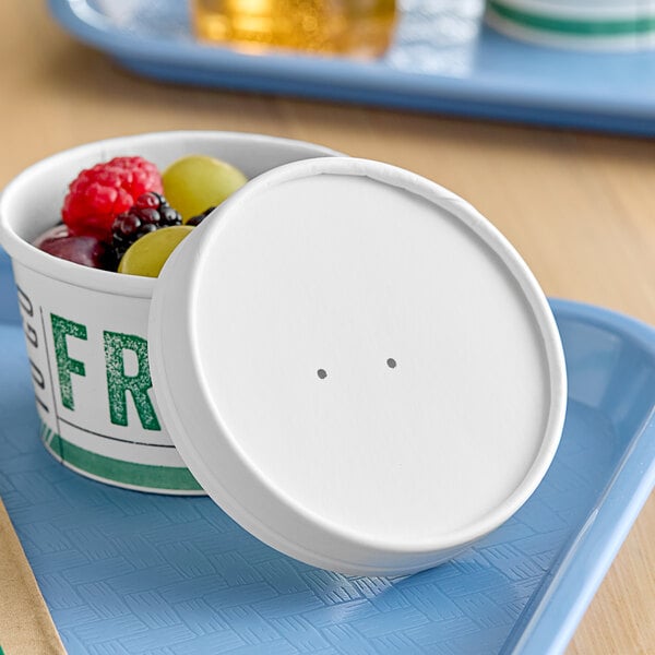 A white Innopak container with a vented lid full of fruit.