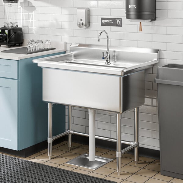 A Steelton stainless steel hand sink with faucet over a white counter.