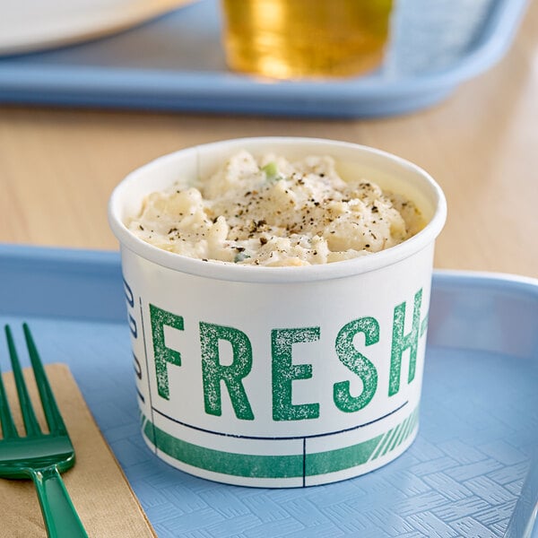 An Innopak poly-coated paper food cup with the words "To Go Fresh" filled with food.